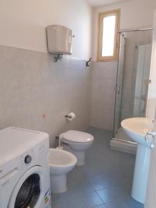 a bathroom with a washing machine and a toilet at 35G Borgonovo in Pizzo
