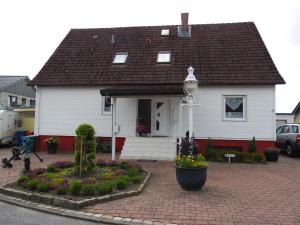 ein weißes Haus mit schwarzem Dach in der Unterkunft Ferienwohnung Müller Bad Segeberg in Bad Segeberg