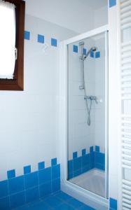 uma casa de banho com um chuveiro com azulejos azuis em Residence Ca' D'Oro em Cavallino-Treporti