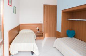 a bedroom with two beds and a blue heart pillow at Residence Ca' D'Oro in Cavallino-Treporti
