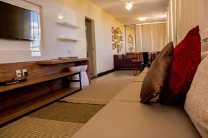 a living room with a couch and a flat screen tv at Hotel Melo in Montes Claros