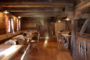 een restaurant met houten wanden en tafels en stoelen bij Schüsslerhof in Campo Tures