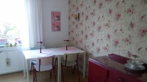 comedor con mesa, sillas y flores en la pared en Bed en Broodje Bloem en Delft