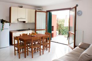a kitchen and dining room with a wooden table and chairs at Residence Ca' D'Oro in Cavallino-Treporti