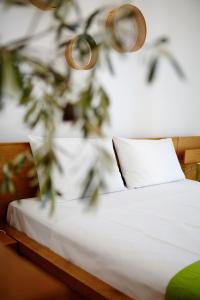 a bed with white sheets and a white pillow at Amarandos Sea View Apartments in Vokaria