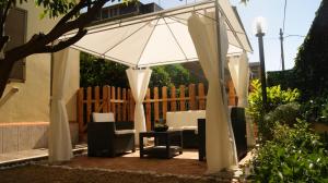 a white umbrella and chairs on a patio at Vegan Inn Airport - Adults Only in Fiumicino