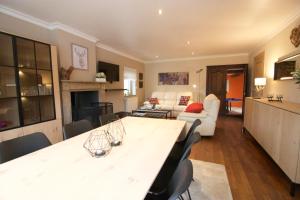 eine Küche und ein Wohnzimmer mit Tisch und Stühlen in der Unterkunft La Petite Maison Maqua in Bouillon