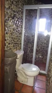 uma casa de banho em pedra com um WC e um chuveiro em Hospedaje Herradura em San Miguel Regla