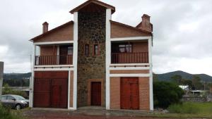 a house with two garage doors and a car at Hospedaje Herradura in San Miguel Regla
