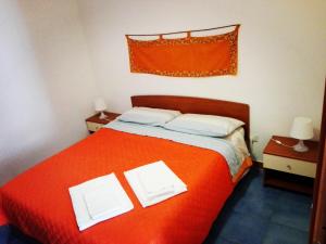 a bedroom with a red bed with two white pillows at A Due Passi Da Tutto in Castellammare del Golfo