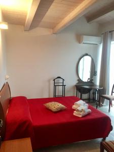 una camera con letto rosso e specchio di Le Limonaie a Mare a San Benedetto del Tronto