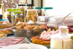 un buffet lleno de diferentes tipos de pan y otros alimentos en Pousada Blue Ocean, en Búzios