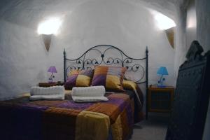 une chambre avec un lit avec deux oreillers dessus dans l'établissement Casas Cuevas El Mirador con piscina y barbacoa, à Fontanar