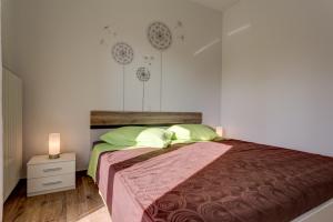 una camera da letto con un letto grande con cuscini verdi di Apartman Tika (2+2)*** a Pola (Pula)
