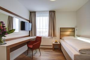 Habitación de hotel con cama y escritorio en INA Boutique 030 Hannover-City en Hannover