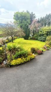 a garden with flowers and a field of grass at Tulla Villa Self Catering in Riverstown