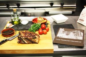 a cutting board with meat and vegetables on a counter at Montaltmar in Sant Vicenç de Montalt