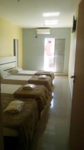 uma fila de camas alinhadas num quarto em Top Mix Hotel em São Bernardo do Campo