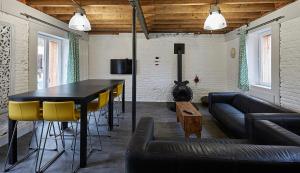 a living room with a black table and yellow chairs at Les Gîtes de L'Yères in Cuverville-sur-Yères