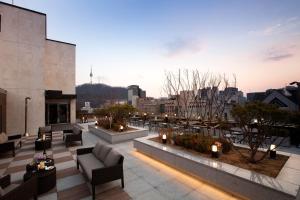 un patio en la azotea con sofás y velas en un edificio en G2 Hotel Myeongdong, en Seúl