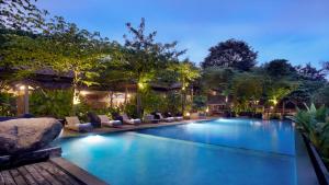 a swimming pool in a resort at night at Desa Alamanis Resort Vila in Cirebon