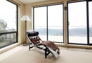 Pokój z fotelem bujanym przed oknami w obiekcie Candoux 4 w mieście Mount Buller