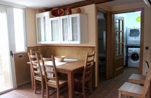 eine Küche mit einem Tisch, Stühlen und einer Mikrowelle in der Unterkunft Casa el Aljibe in Lanaja