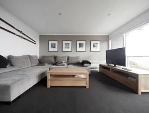 a living room with a couch and a flat screen tv at Elkhorn 7 in Mount Buller