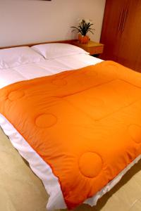 an orange blanket on a bed in a bedroom at Enginyapartaments in Figueres