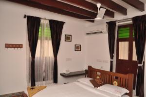 Schlafzimmer mit einem Bett und einem Fenster in der Unterkunft Rams Inn in Thanjavur