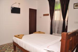 - une petite chambre avec un lit et une fenêtre dans l'établissement Rams Inn, à Thanjavur