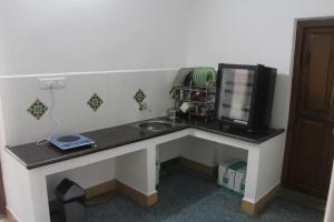 a desk with a sink and a computer monitor on it at Rams Inn in Thanjāvūr