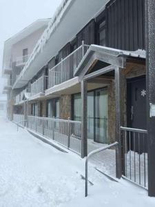 a building with snow on the ground in front of it at Molony's 12 in Mount Buller