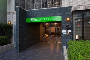 un edificio con una señal verde en la parte delantera de un edificio en FLEXSTAY INN Ekoda, en Tokio