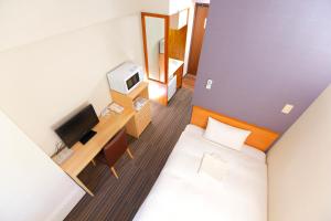 a small hotel room with a bed and a television at FLEXSTAY INN Ekoda in Tokyo
