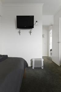 a bedroom with a bed and a tv on a wall at Reindeer 9 in Mount Buller