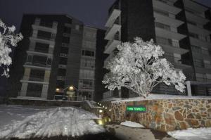 a street sign in the snow in front of a building at Twin Towers 102a AMS Mt Buller in Mount Buller