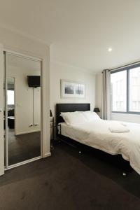 a bedroom with a large bed and a mirror at Valley View 203 in Mount Buller