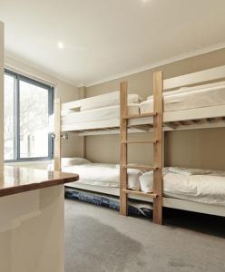 two bunk beds in a room with a window at Valley View 203 in Mount Buller