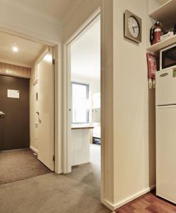 a hallway with a door and a clock on the wall at Valley View 203 in Mount Buller