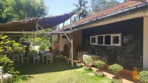 a patio of a house with a table and chairs at Surfing Wombats in Weligama