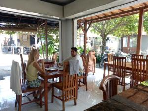 a man and woman sitting at a table in a restaurant at Radya Homestay in Nusa Lembongan