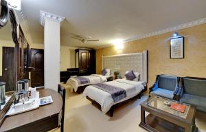 Hotel City Heart Premium في شانديغار: غرفة فندقية بسريرين واريكة