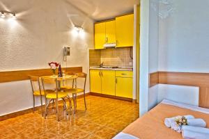 kuchnia z żółtymi szafkami oraz stołem i krzesłami w obiekcie Apartment Bonaca Klek w mieście Klek