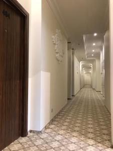 モスクワにあるホテル サドブニチェスカヤの白壁・タイルフロアの廊下