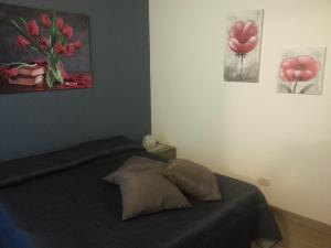 a bedroom with a bed and paintings on the wall at Appartamento Vincenzina in Lampedusa