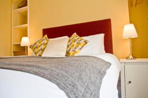 a bedroom with a bed with white sheets and pillows at The Red Lion in Knighton