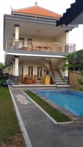 a villa with a swimming pool in front of a house at Obama House Ubud in Ubud