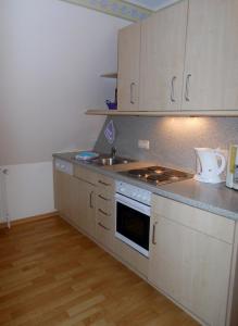 a kitchen with white cabinets and a sink and a stove at Ferienwohnung Goting Nr.3 in Goting