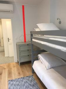 ein Schlafzimmer mit 2 Etagenbetten und einem roten Streifen an der Wand in der Unterkunft Le Luciole in Marseille